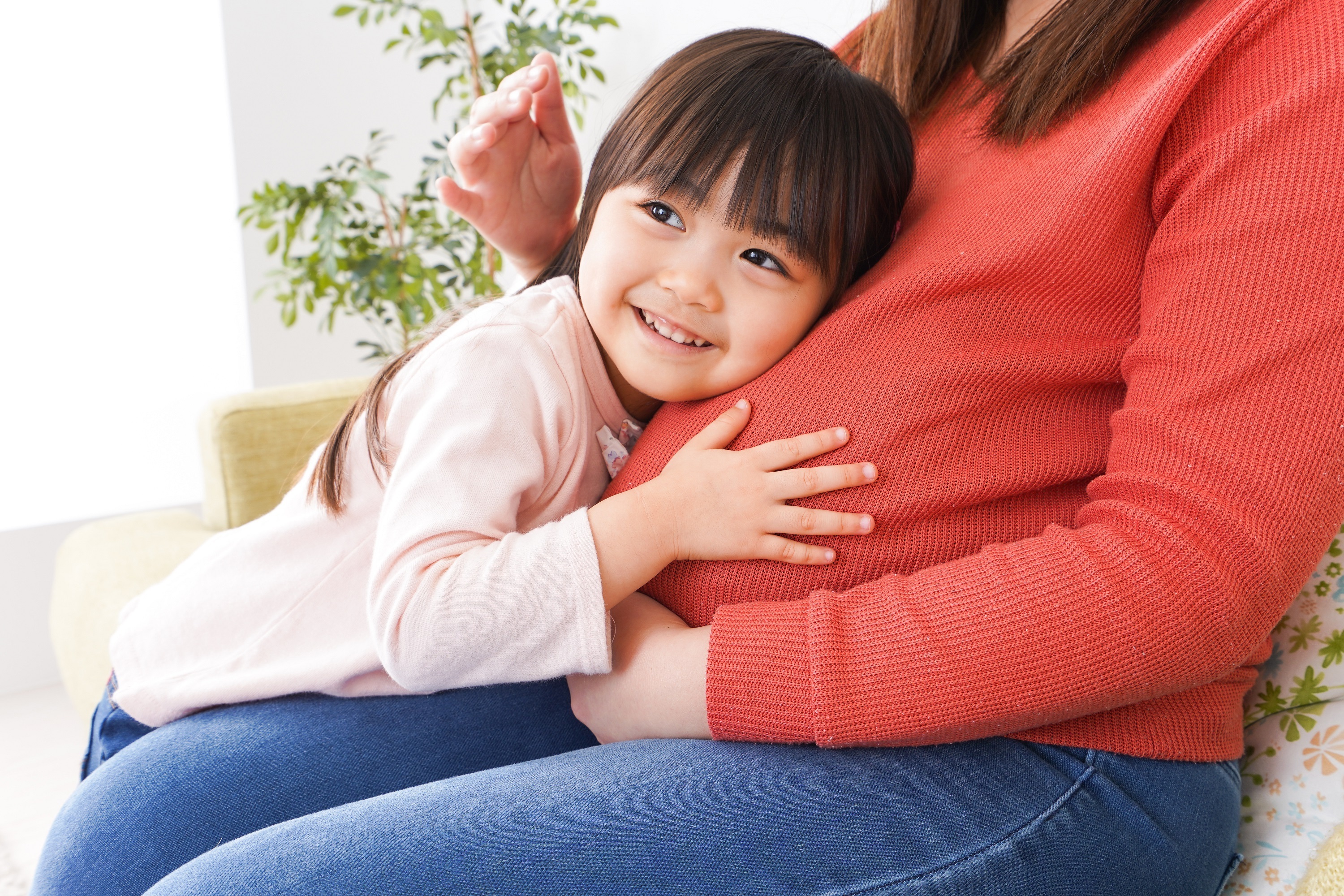 おなかに耳を寄せる子ども